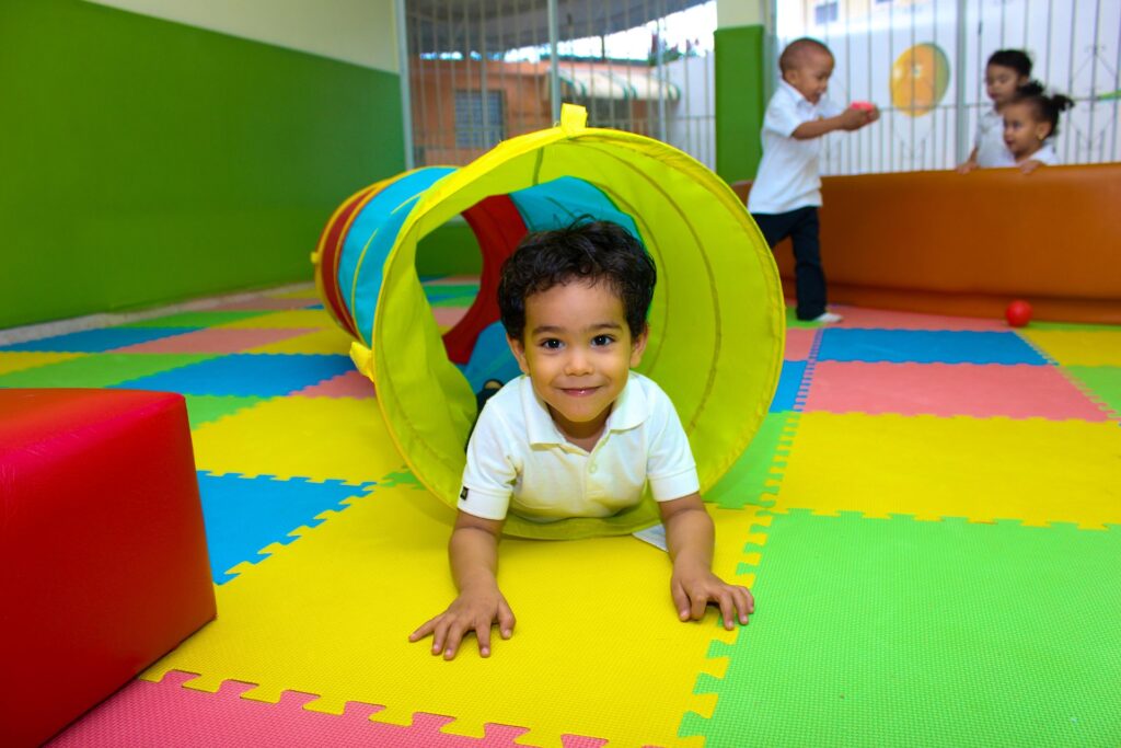 A toddler crawls through a play tunnel