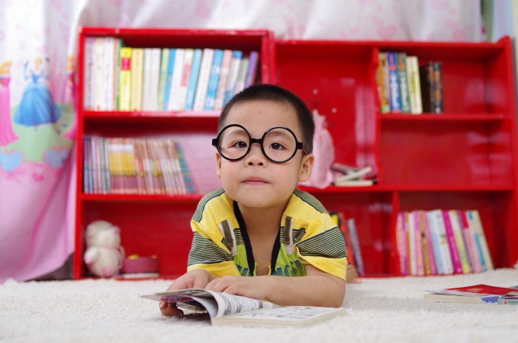 A child reads a book on the floor