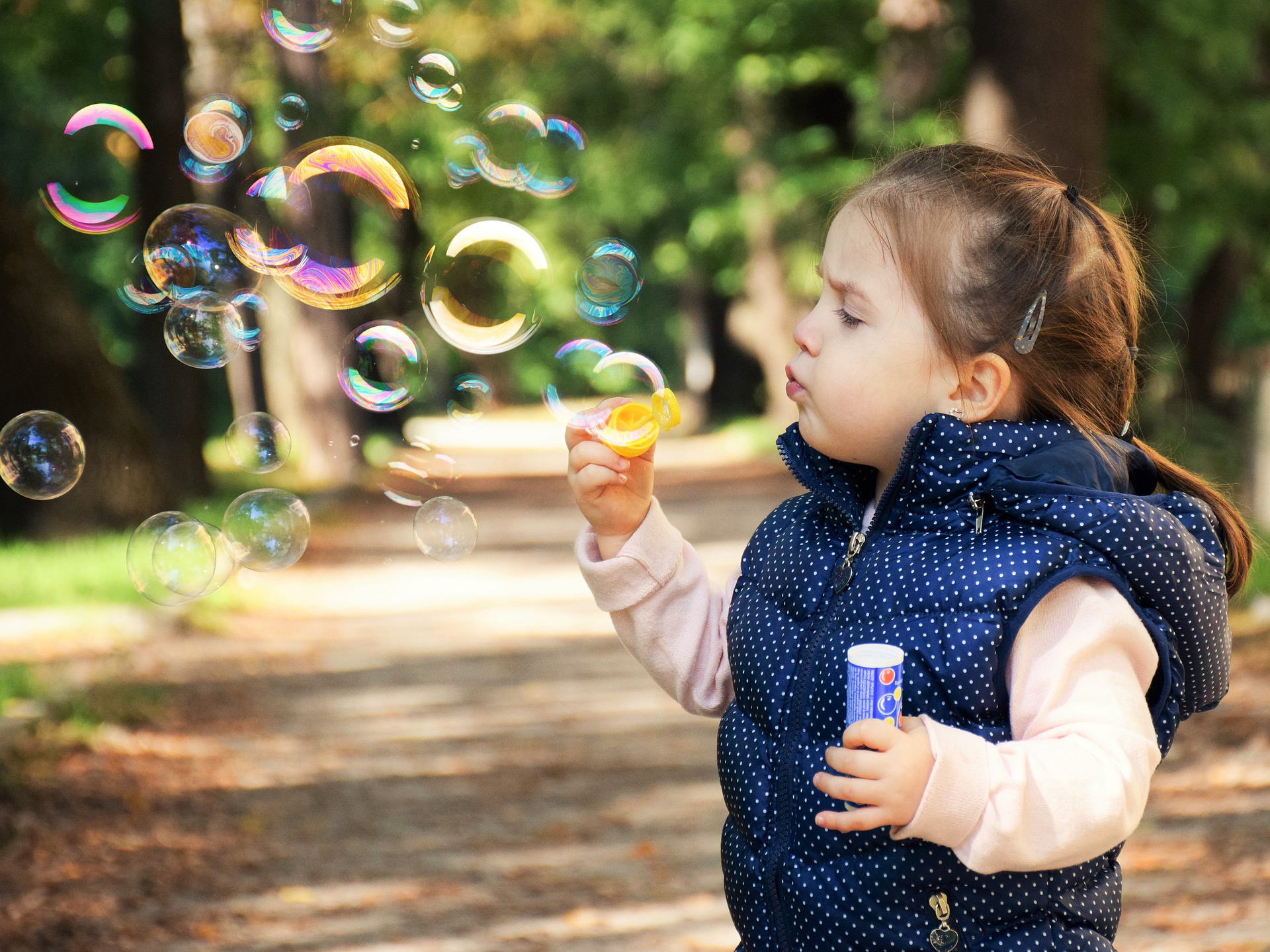 A young girl blows bubbles