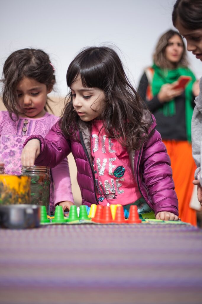 Two young girls do a color sorting activity